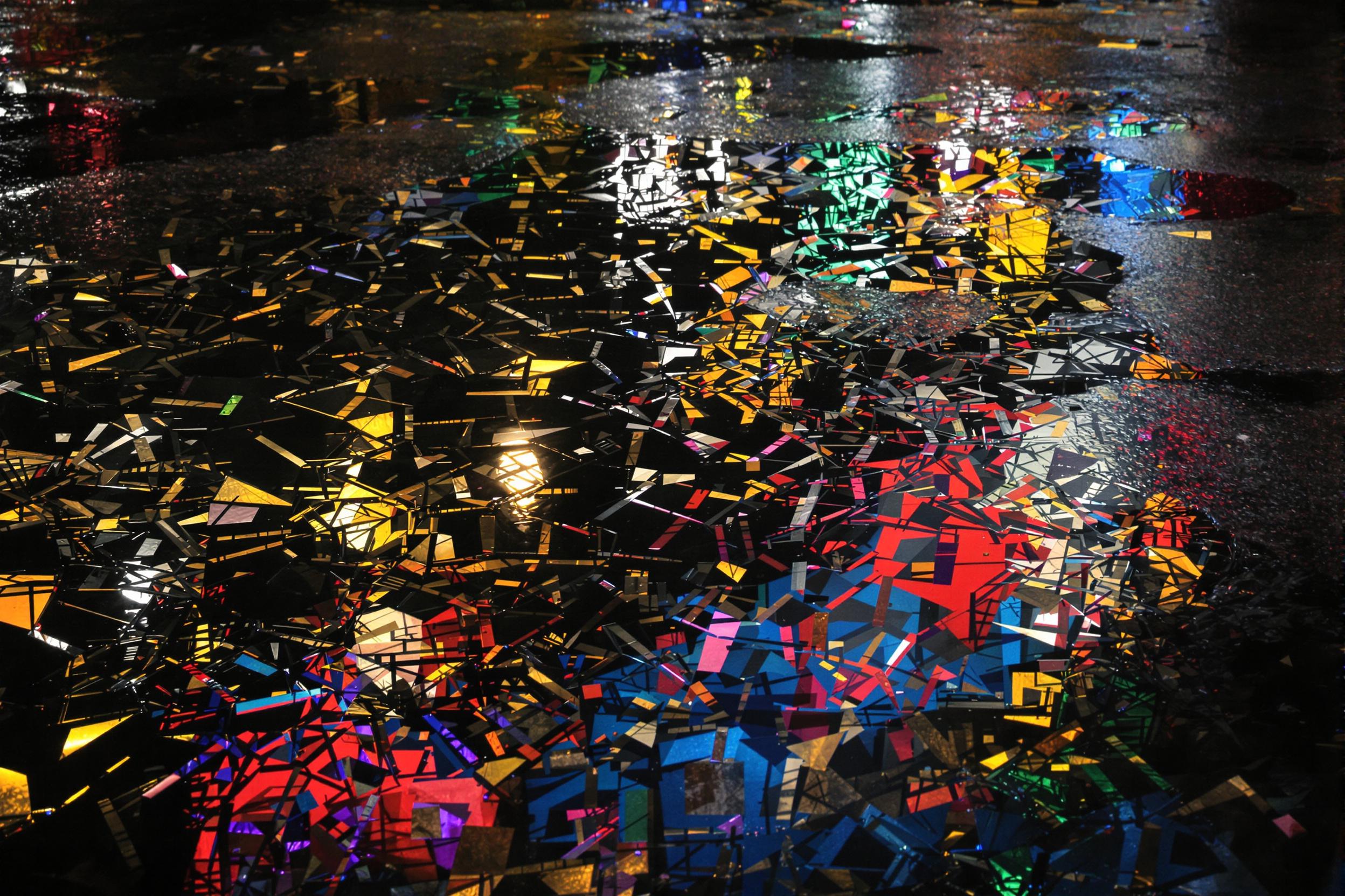 Discover the hidden beauty of urban landscapes through this captivating abstract photograph. A puddle reflects fragmented city lights, creating a mesmerizing interplay of color and form that transforms the ordinary into extraordinary.