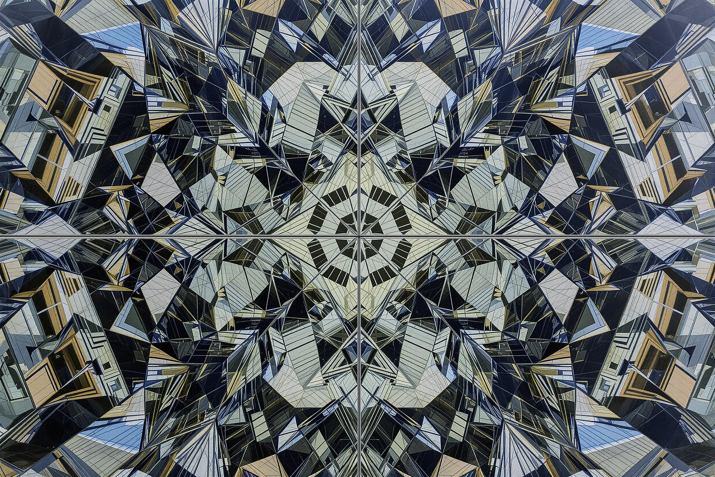 Explore the mesmerizing intersection of architecture and abstraction in this striking photograph. A modern glass building facade creates a kaleidoscopic pattern of reflections, transforming familiar urban structures into a captivating geometric composition.