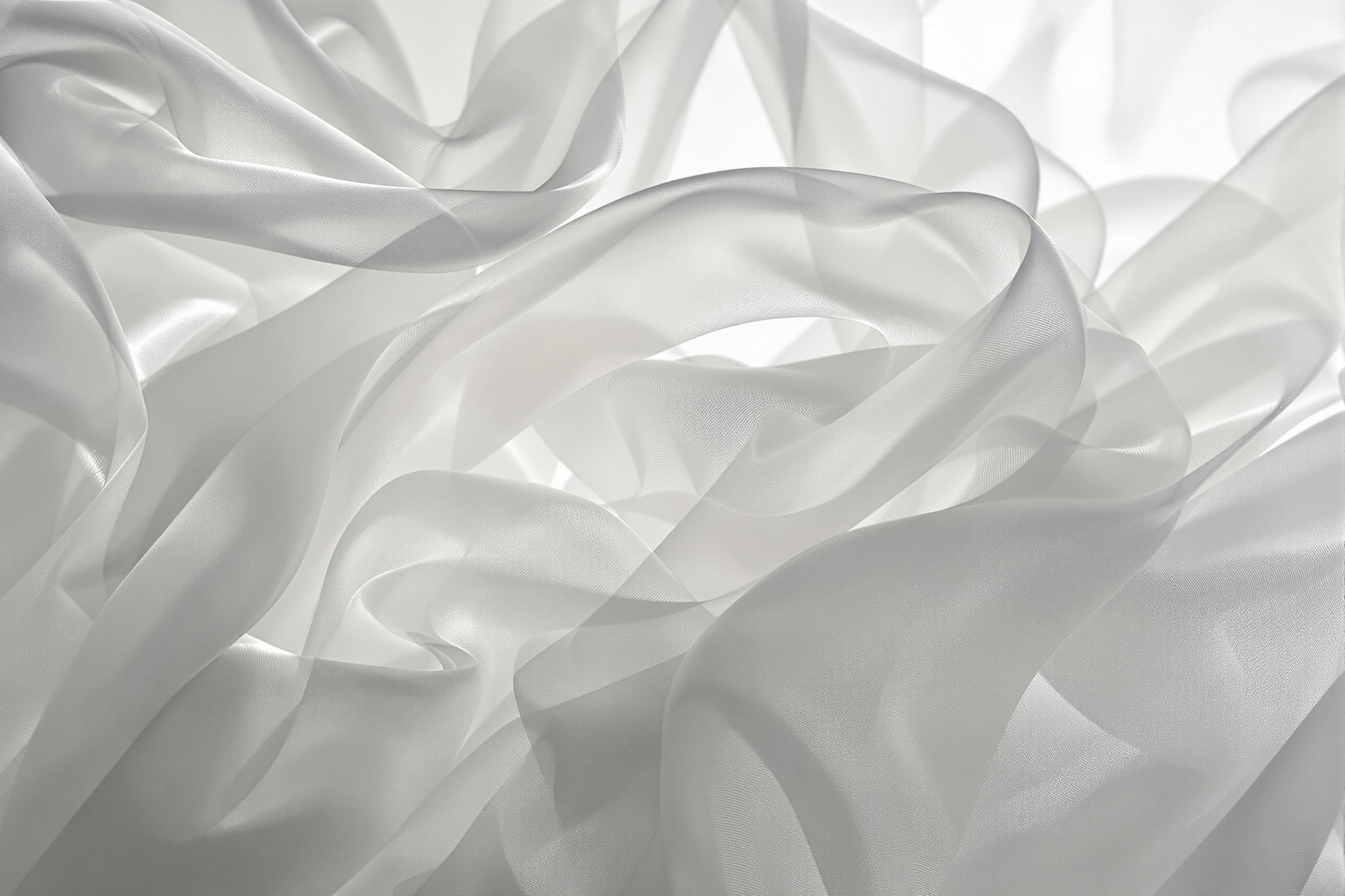 Delicate folds of translucent silk fabric create an abstract landscape of light and shadow. Soft curves and gentle ripples form a mesmerizing composition, showcasing the interplay between texture, movement, and luminosity.