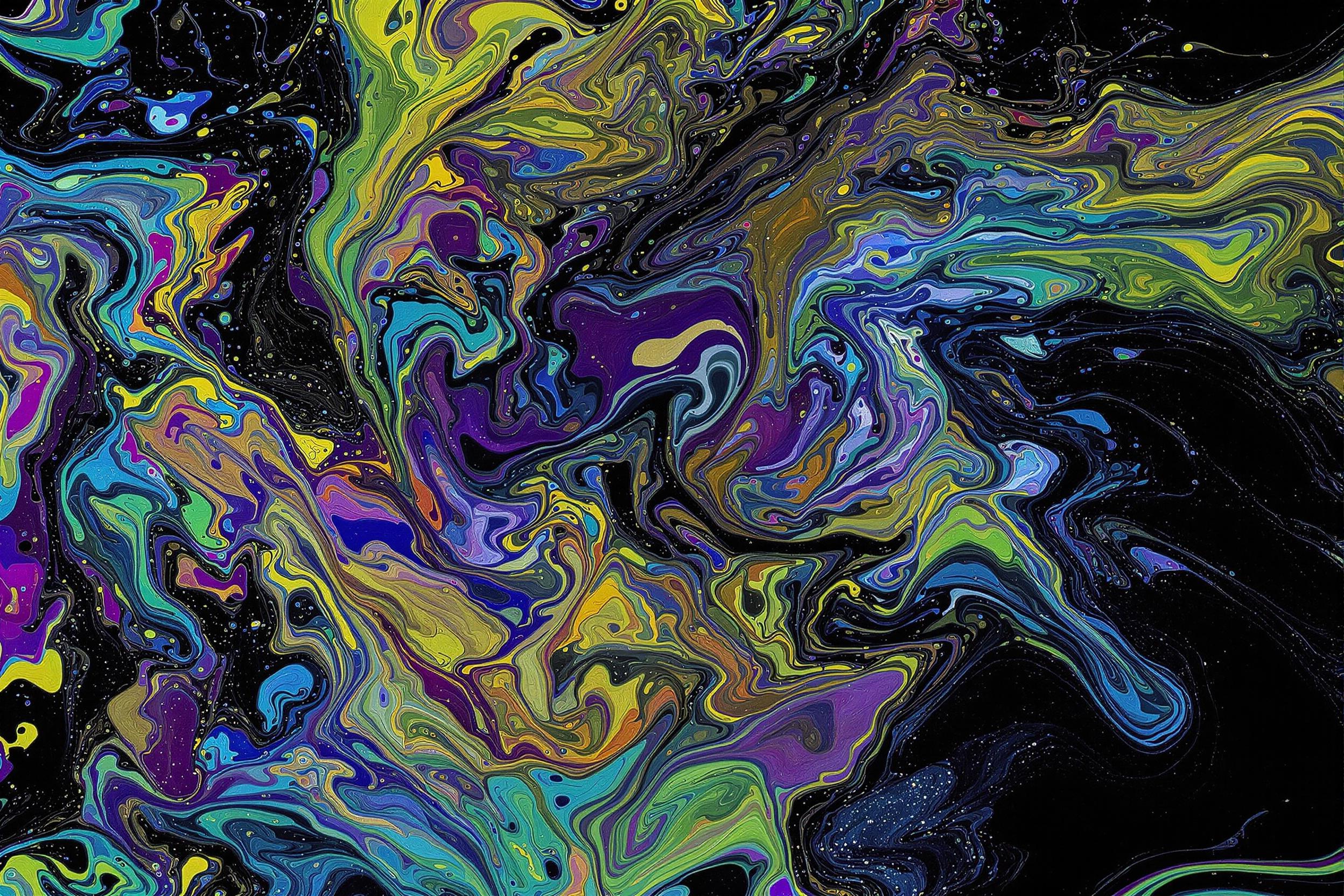 Explore the mesmerizing world of oil and water in this captivating abstract photograph. A kaleidoscope of vibrant colors swirls across a dark surface, creating intricate patterns reminiscent of peacock feathers. This image showcases the interplay of light refraction and fluid dynamics, resulting in a stunning display of nature's artistry.