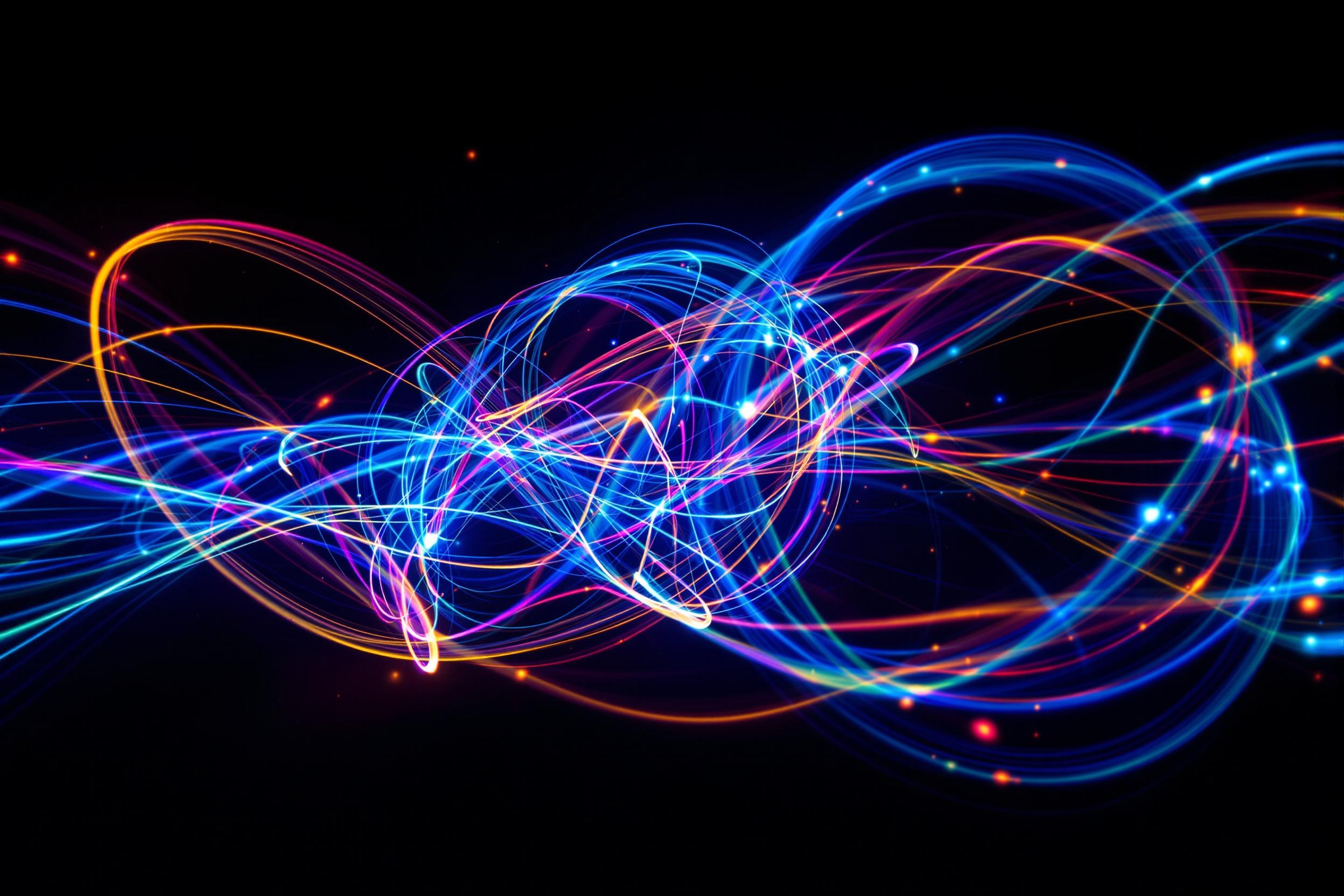 Explore the mesmerizing world of quantum physics through abstract photography. Vibrant light trails from fiber optic cables intertwine and dance across a pitch-black background, symbolizing the mysterious phenomenon of quantum entanglement.