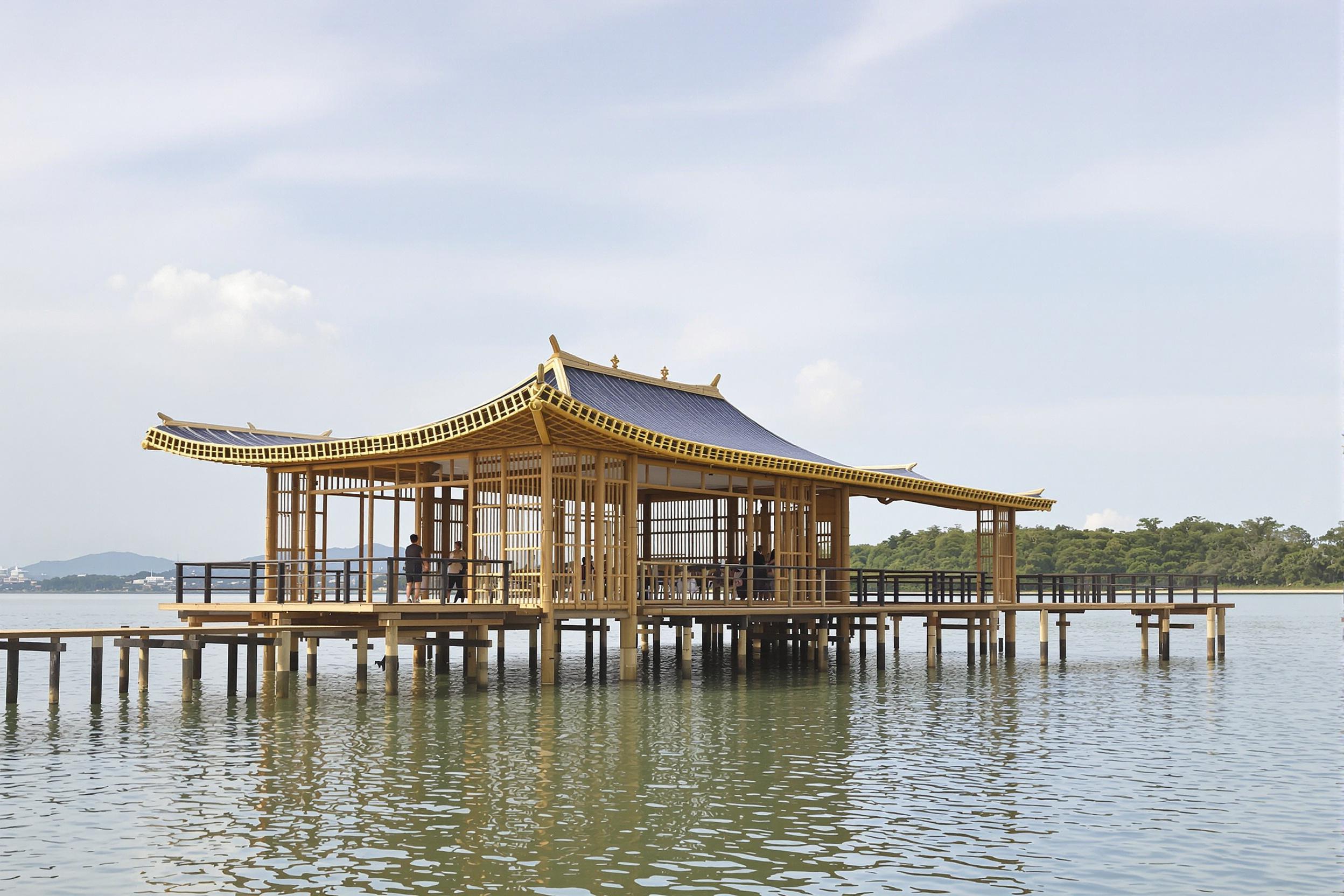 Discover an innovative floating pavilion crafted entirely from sustainable bamboo. This architectural marvel seamlessly blends traditional Asian design with modern eco-friendly principles, creating a serene waterfront structure that appears to hover effortlessly above a tranquil lake.