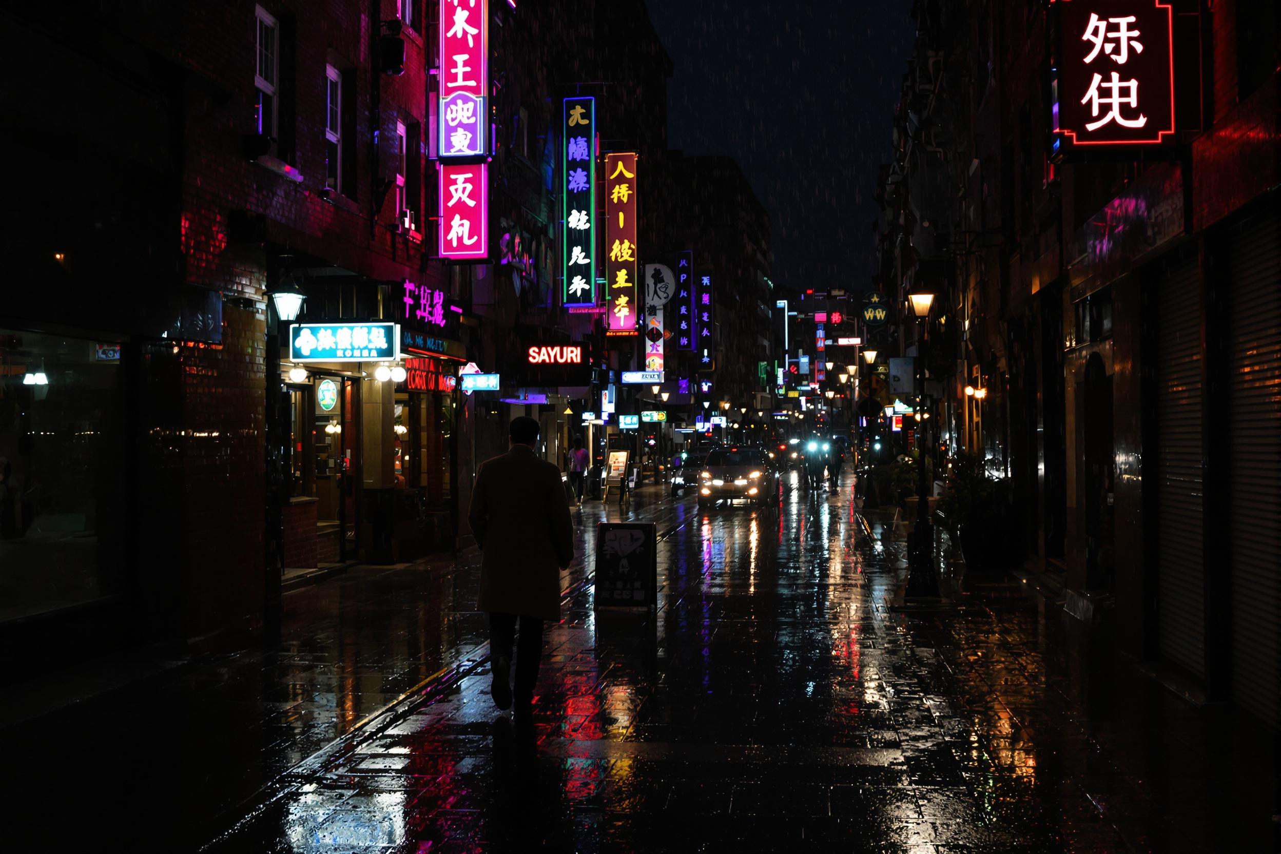 A rain-soaked city street at night, illuminated by neon signs and streetlamps. Reflections shimmer on the wet pavement, creating a moody, film noir atmosphere. A lone figure in a trench coat walks away from the camera, adding mystery to the scene.