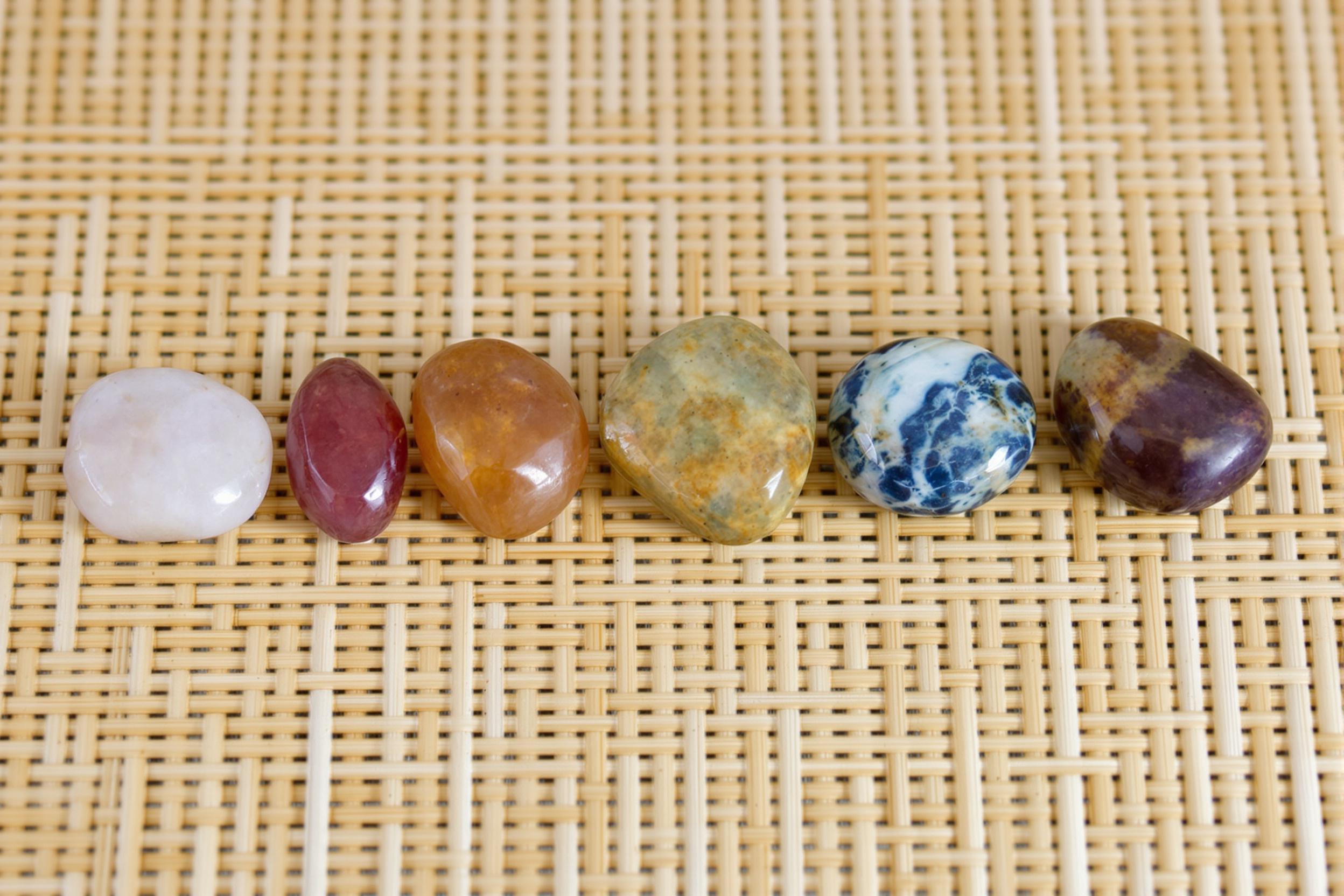 Explore the world of energy healing with this captivating arrangement of chakra stones on a natural bamboo mat. Seven vibrant gemstones align perfectly, symbolizing balance and harmony in holistic wellness practices.