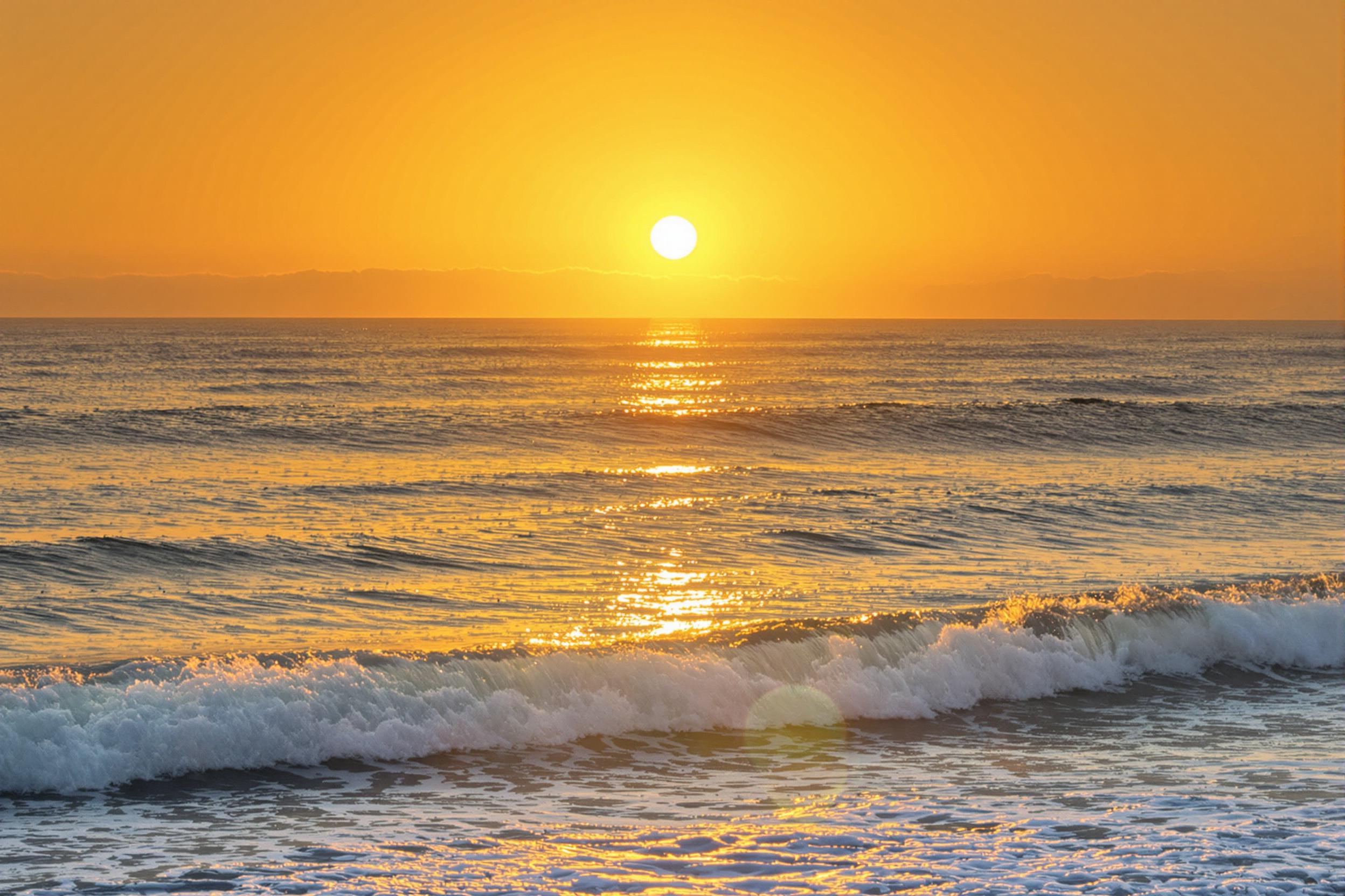 A breathtaking view of the sun rising over calm ocean waves, casting golden hues across the water. This tranquil scene evokes peace and serenity, perfect for relaxation and inspiration.