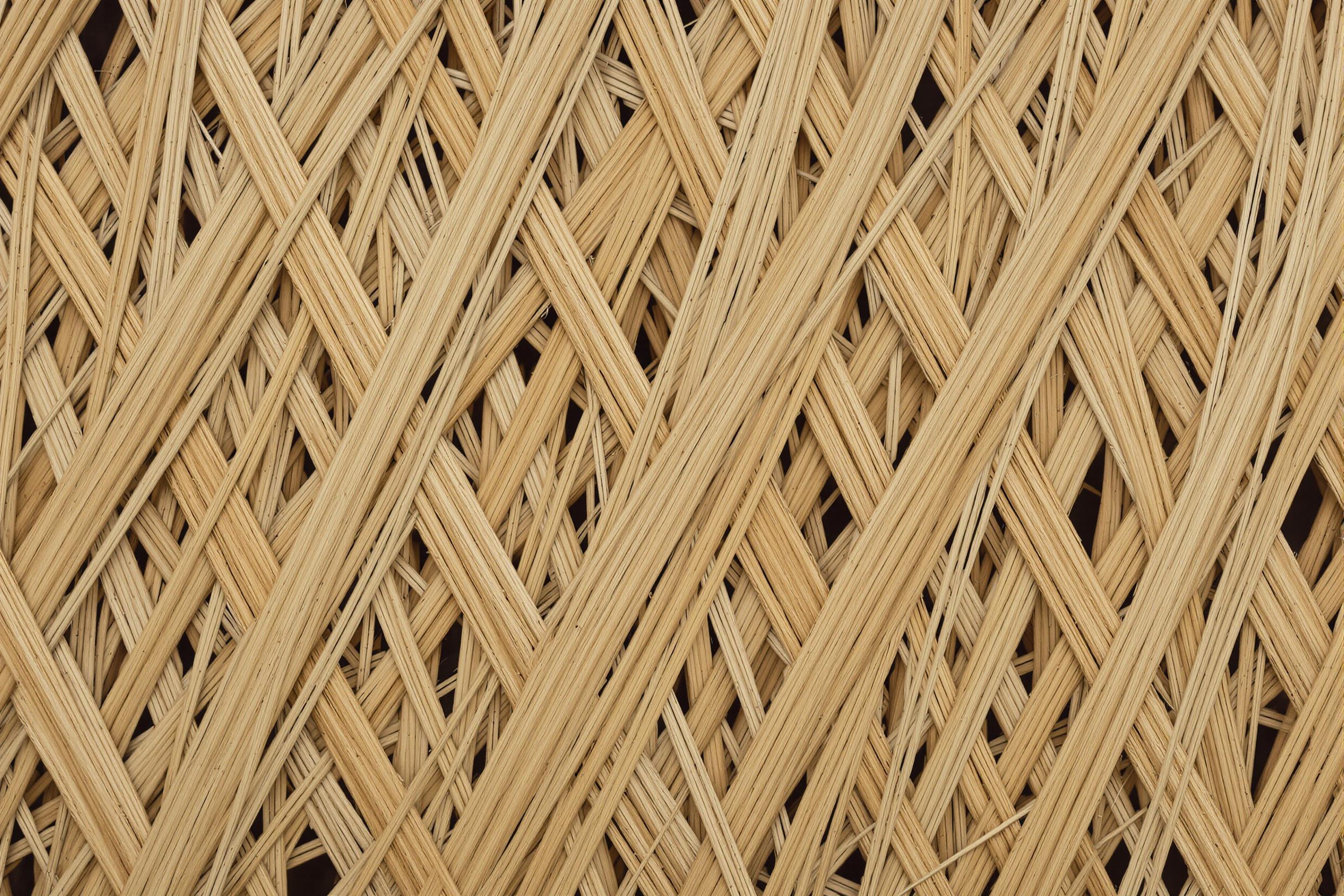 Extreme close-up of intricately woven rattan fibers, showcasing the natural elegance of this sustainable material. Golden-brown strands intertwine in a mesmerizing pattern, highlighting the craftsmanship and organic beauty of handwoven textures.