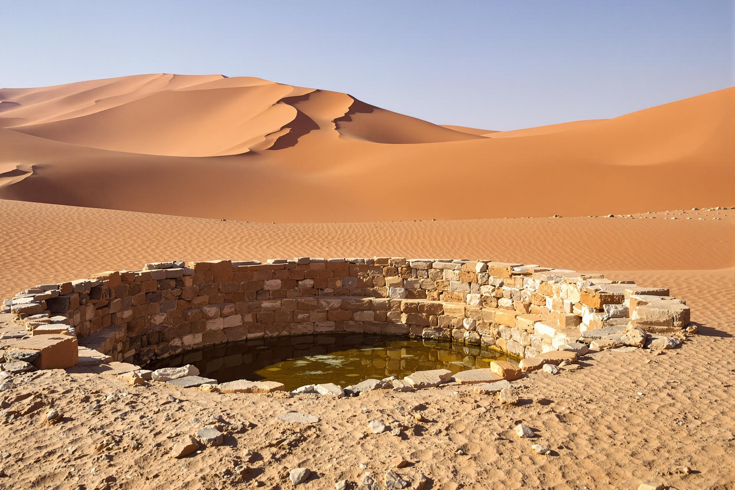 Discover a hidden gem of the Sahara - an ancient Bedouin well surrounded by towering sand dunes. This oasis of life in the vast desert showcases the ingenuity of nomadic cultures and the stark beauty of arid landscapes.